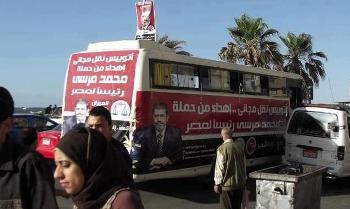 Sohag: Buses of Mursi take the voters from their houses to vote for him