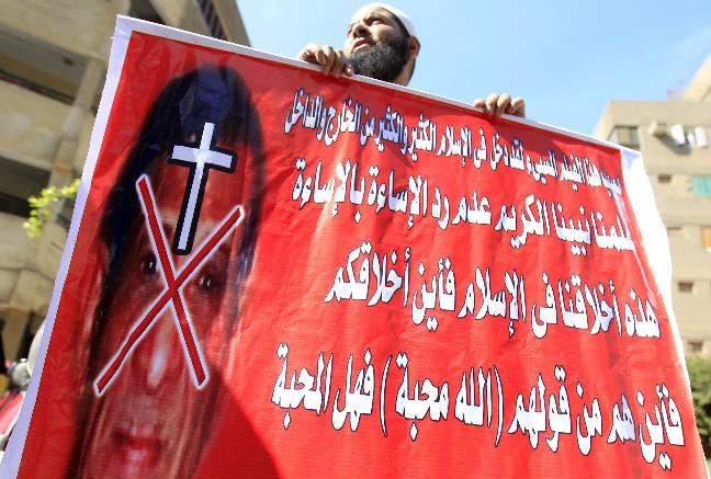 An Egyptian Salafist man holds an anti-Coptic Christian banner outside a courthouse in Cairo
