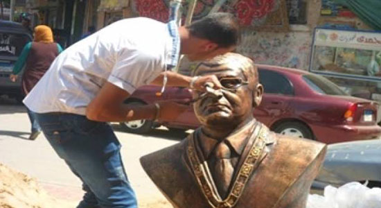 Unidentified men smash statue of interim president 