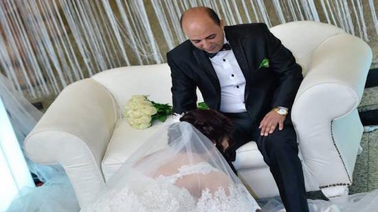 A bride washes the feet of her groom in wedding ceremony