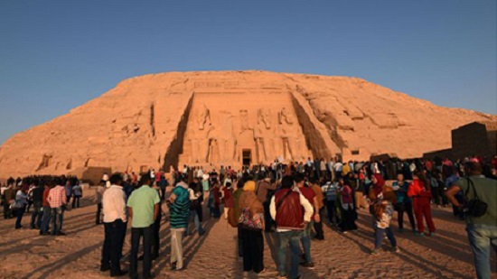 Tourists watch solar illumination of King Ramses II at Aswan's Abu Simbel